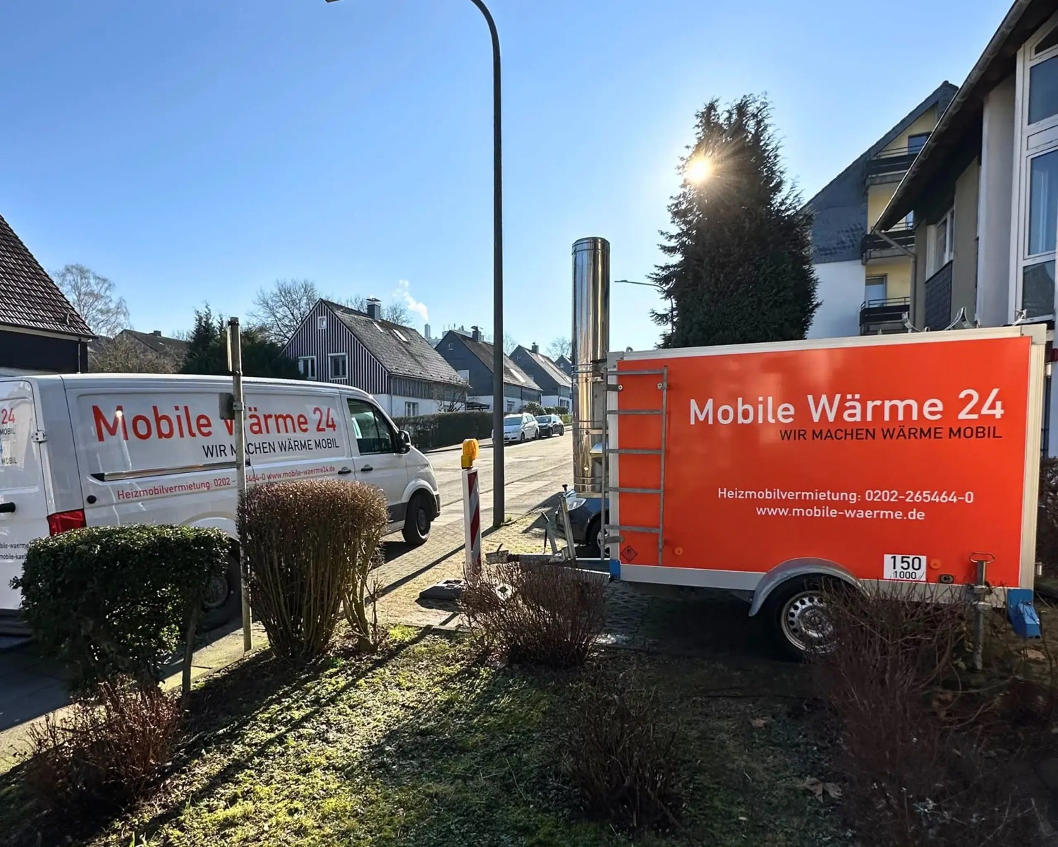 Heizanhänger von Mobile Wärme 24 neben einem Wohnhaus im Einsatz