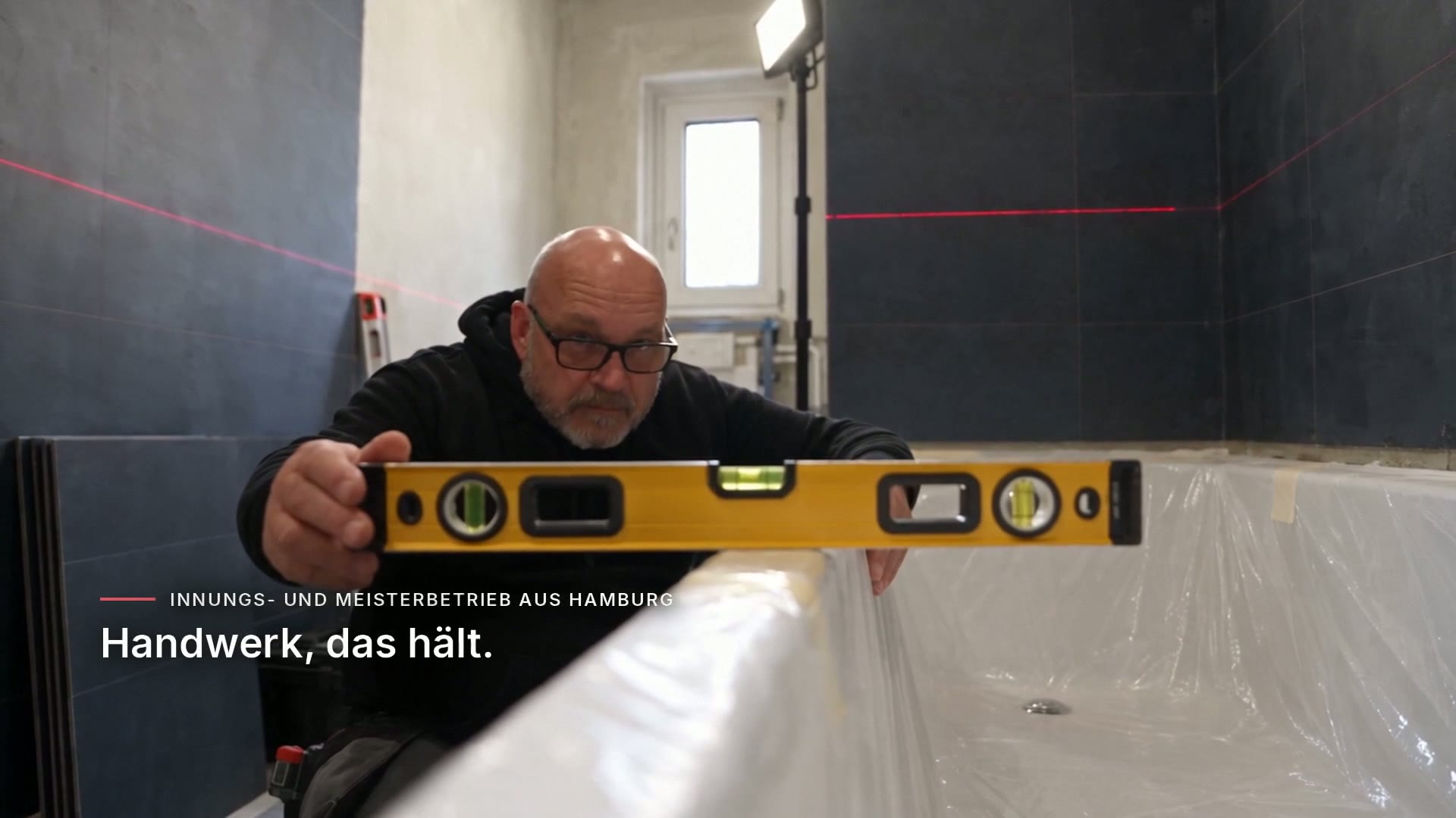 Auszug aus dem Film von Czerlitzki Haustechnik: Handwerker mit Wasserwaage bei einer Badsanierung
